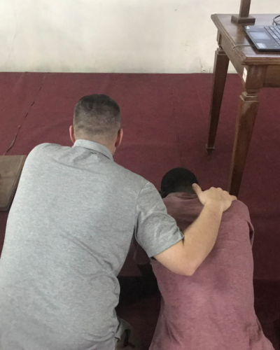 Two people praying at an alter