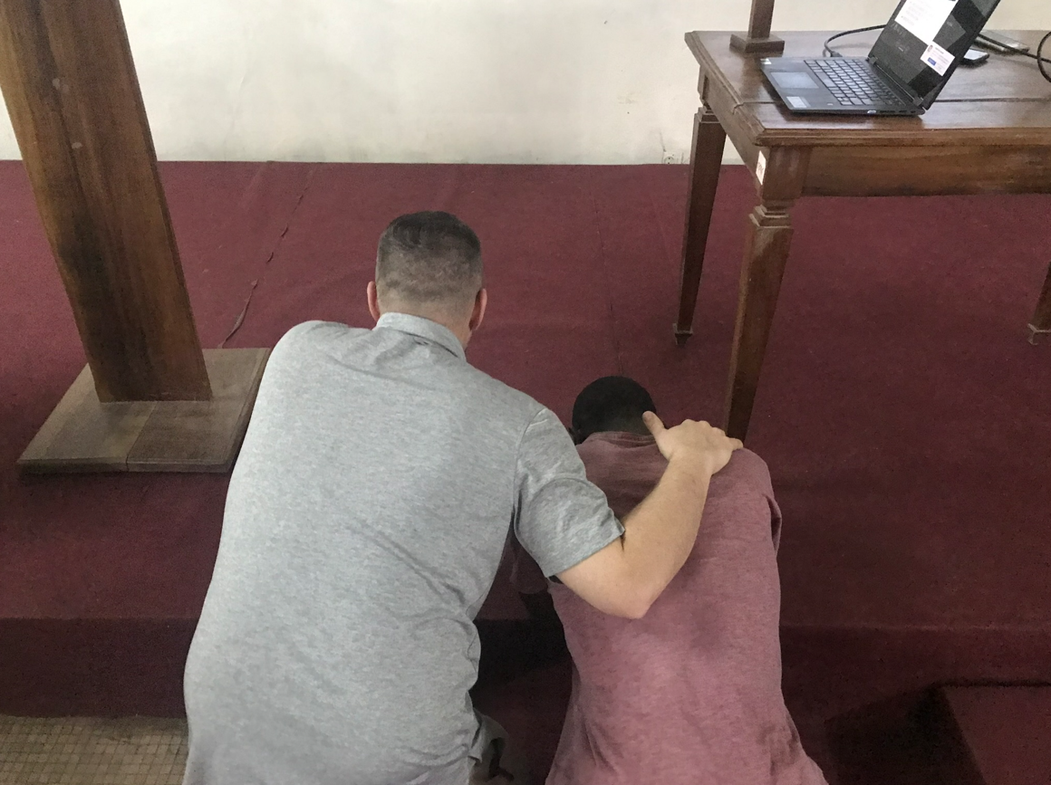 Two people praying at an alter